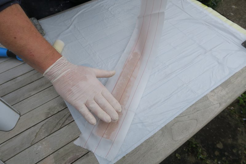 Placing peel ply over wet epoxy resin