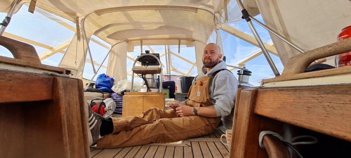 Shipwright sat eating lunch inside his sailboat made with west system epoxy.