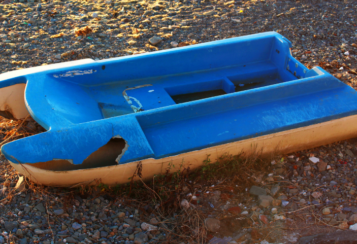 A fibreglass boat in need of repair washed up on beach